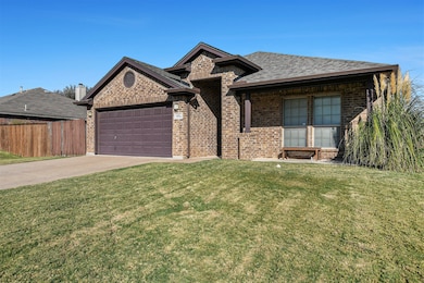 View of front facade with concrete driveway, brick siding, an attached garage, and roof with shingles