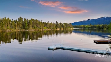 Dock area featuring a water and mountain view and a view of trees
