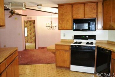 Full range and microwave with dining area beyond.