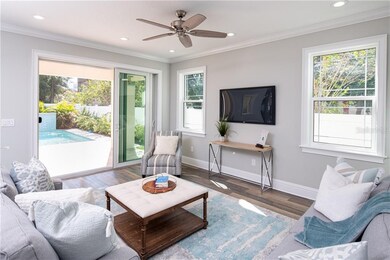 Family room, which is open to the kitchen, has sliders to the back patio and views of the pool.