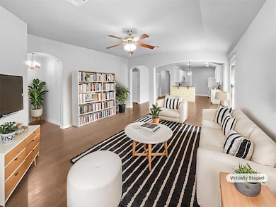 Living area featuring arched walkways, wood finis