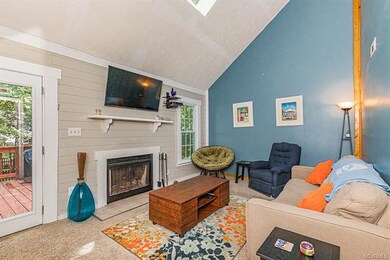 Living room has tall ceilings with a sky light and