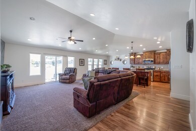 Living room with recessed lighting, ceiling fan, light wood finished floors, and vaulted ceiling