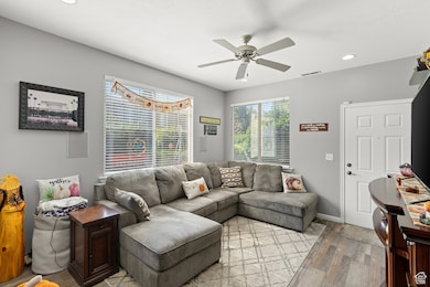 Living room with wood-type flooring, recessed lighting, and ceiling fan