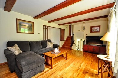 Another view of the living room with entry from the lower level, entry to the 3 bedrooms and off to the left is entry to the dining room and kitchen