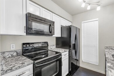 Kitchen with white cabinets, black appliances, and