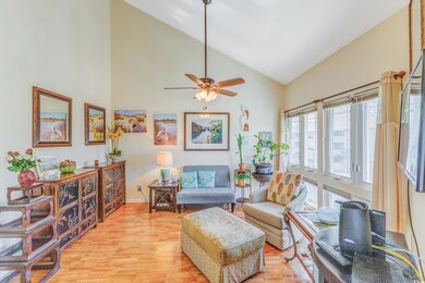 Living room featuring light wood-style flooring, high vaulted ceiling, and ceiling fan