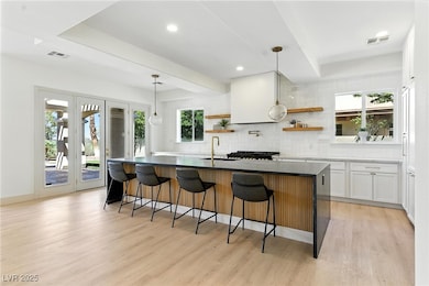 Kitchen featuring backsplash, open shelves, light