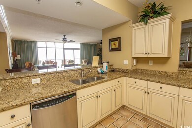 Kitchen with sink, light stone countertops, and di