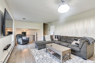 Living room with a baseboard heating unit and light hardwood / wood-style floors