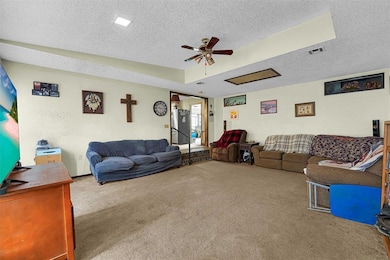 Living area featuring a textured ceiling, visible 