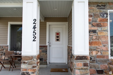 Property entrance featuring stone siding and covered porch