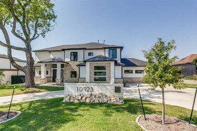 View of front of property with driveway, stone siding, roof with shingles, and a garage