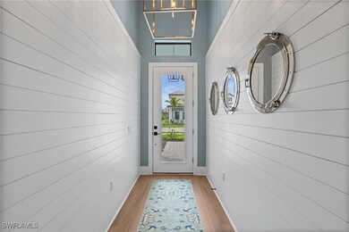Doorway with light wood finished floors and a chan