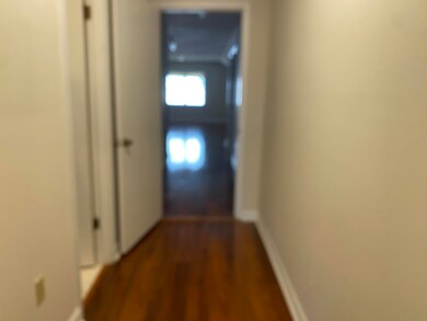 Hall with dark wood-style floors and baseboards