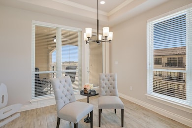 Dining area featuring wood finished floors, baseboards, a chandelier, and crown molding and plenty of natural light.