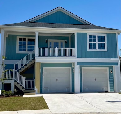 Raised beach house with stairs, board and batten siding, and roof with shingles