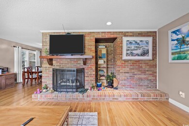 Living area featuring a textured ceiling, wood finished floors, and a fireplace