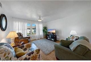 Living area featuring ceiling fan and wood finishe