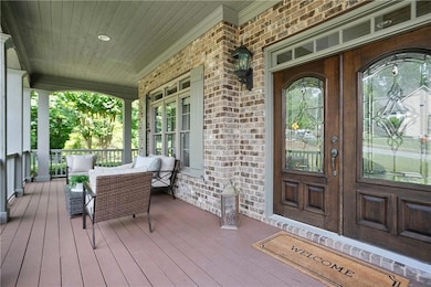 View of exterior entry featuring a porch and brick siding