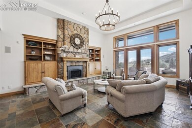 The main level great room boasts soaring ceilings, a striking stone fireplace, and custom built-ins, while French doors open seamlessly to the expansive outdoor living area.