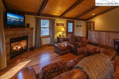 A large, welcoming great room with vaulted wood ceilings and a gas log fireplace