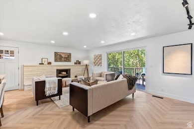Living area featuring a fireplace, recessed lighting, and a textured ceiling