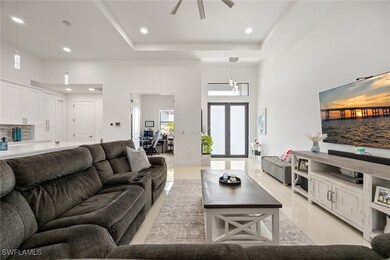 Living room with recessed lighting, a raised ceili
