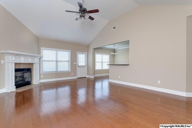 Impressive great room featuring vaulted ceiling, gas log fireplace and ceiling fan.
