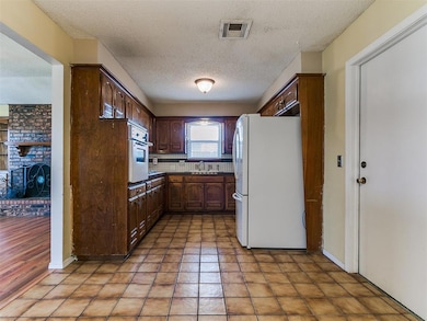 Kitchen featuring visible vents, freestanding refr