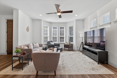 Living room with wood finished floors, recessed lighting, and ceiling fan