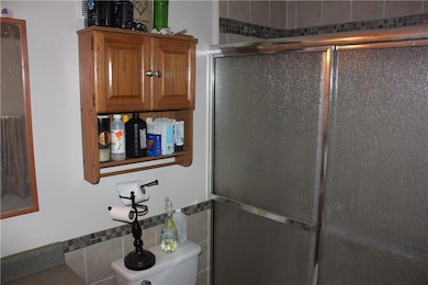 Full bathroom with a stall shower and tile walls