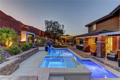 Pool at dusk with an outdoor fireplace, an in-grou