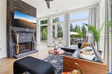 Living room featuring wood finished floors, french doors, and a brick fireplace