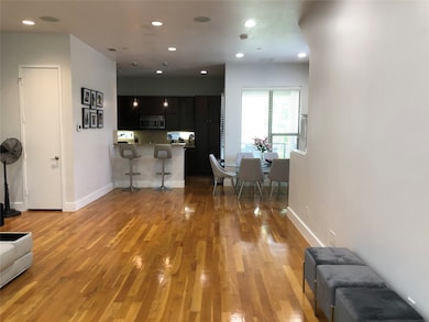 Living area with light wood finished floors and recessed lighting