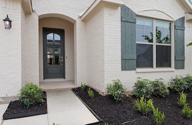 View of exterior entry featuring brick siding