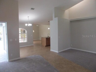 view from doube entry , living left with sliders to pool, dining right with skylight, breakfast nook beyond left kitchen right and family room at rear of photo