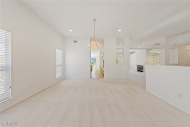 Unfurnished room with a chandelier, light carpet,
