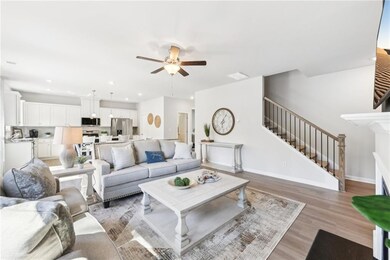 Living room featuring stairway, a ceiling fan, lig