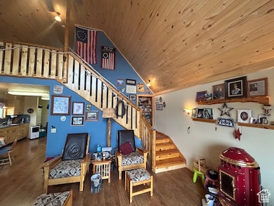 Stairway with wood ceiling, high vaulted ceiling, and wood finished floors