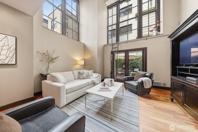 Soaring 20' ceilings and oversized windows fill the living room with natural light.