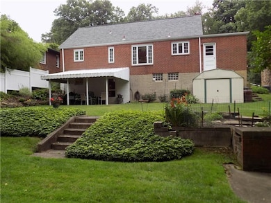 Terraced backyard with covered patio and shed.