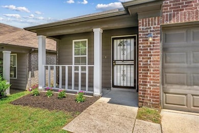 Doorway to property featuring brick siding, a porch, and a garage