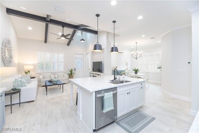 Kitchen with sink, white cabinetry, decorative lig