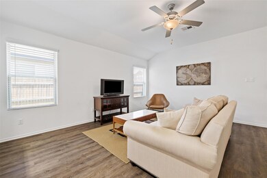 Living area featuring a ceiling fan, wood finishe