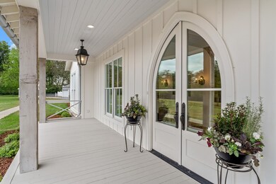 The large covered front porch offers storybook views of the property outside and invites you inside to a luxurious home.