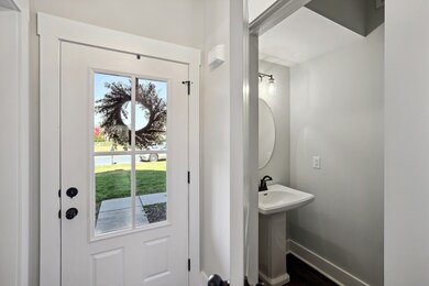 The light filled foyer welcomes guests. The convenient half-bathroom is adjacent.