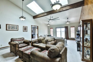 Carpeted living room with a skylight, high vaulted