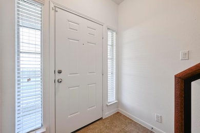 Foyer with light tile patterned flooring and base