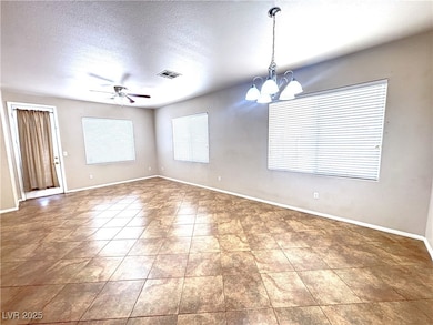 Spare room featuring a chandelier, ceiling fan, a